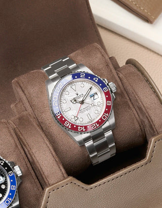 Rolex GMT Master 2 Meteorite with a silver, blue, and red bezel on a taupe cushion in a watch roll