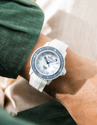 White Vertech rubber strap for Blancpain x Swatch Scuba Fifty Fathoms Antarctic Ocean – worn on wrist with dark green linen jacket, white dial and grey bezel with white case, front angle view