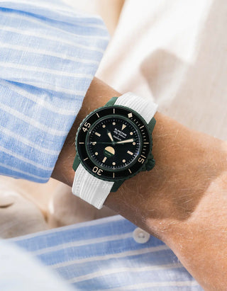 White Vertech rubber strap for Blancpain x Swatch Scuba Fifty Fathoms Green Abyss – worn on wrist with light blue striped shirt, black dial and black bezel with green case, front angle view