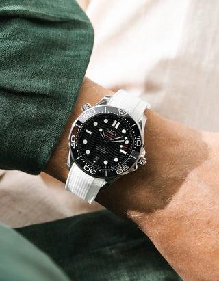 White Vertech rubber strap for Omega Seamaster Diver 300 42mm – worn on wrist with dark green linen jacket, black dial and bezel, side angle view