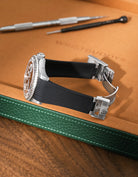 Black Vertech FKM rubber strap for Rolex Yacht-Master 116622 and 126622, integrated seamless fit with original clasp, resting on a leather valet tray.