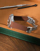 Brown textured FKM rubber watch band for Rolex Yacht-Master 116622 & 126622, premium integrated design for original clasp, shown on a brown leather tray.