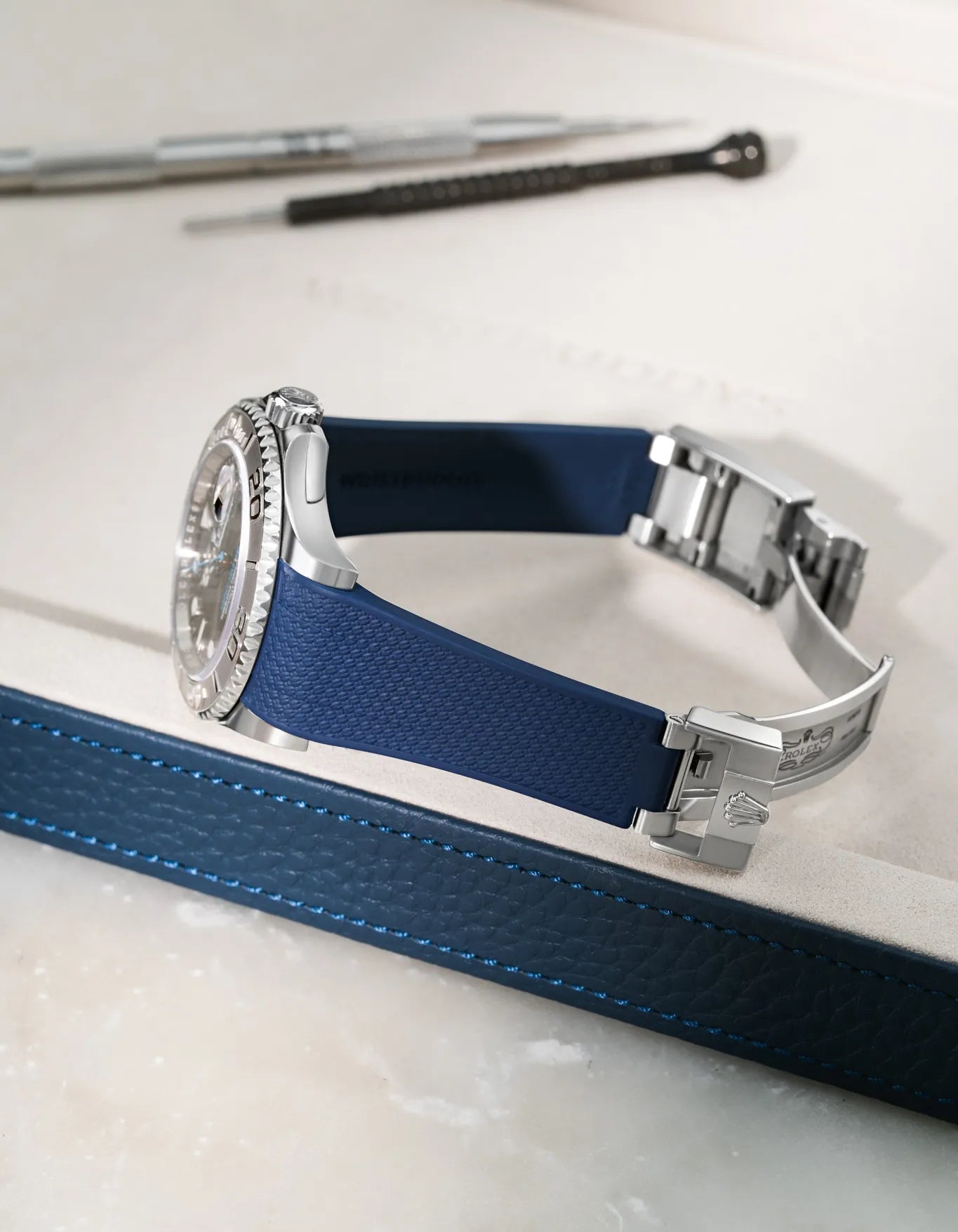 Navy blue Vertech FKM rubber strap for Rolex Yacht-Master 116622 and 126622, integrated seamless fit with original clasp, resting on a leather valet tray.