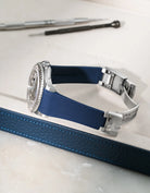 Navy blue Vertech FKM rubber strap for Rolex Yacht-Master 116622 and 126622, integrated seamless fit with original clasp, resting on a leather valet tray.