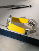 Yellow integrated FKM rubber watch band for Rolex Yacht-Master 116622 & 126622, Vertech textured finish with original clasp, resting on a white valet tray.