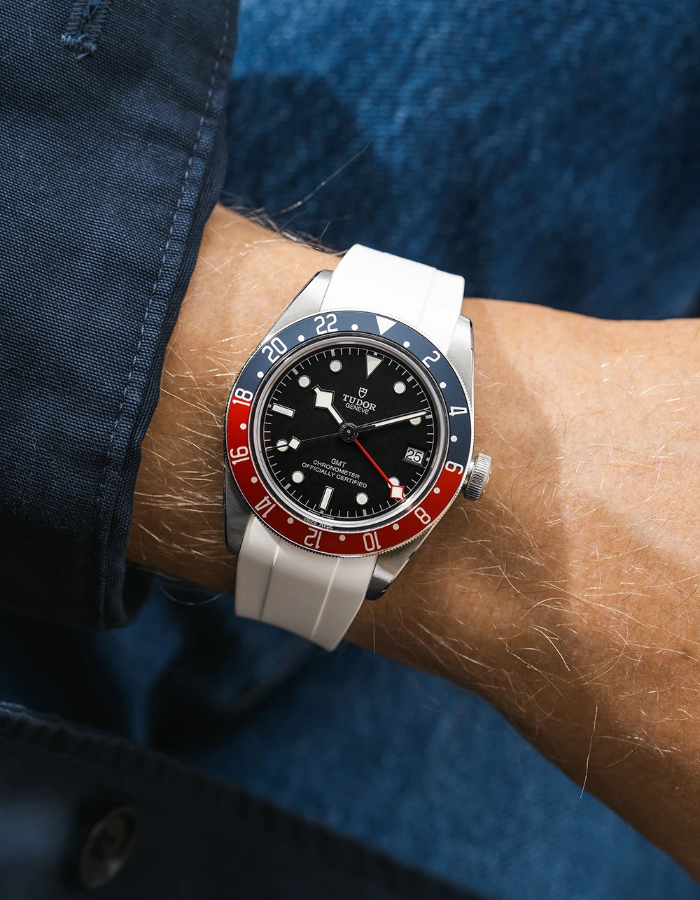 Tudor GMT watch on a person's wrist with a white FKM rubber watch strap from Wristbuddys and red & blue accents on the bezel