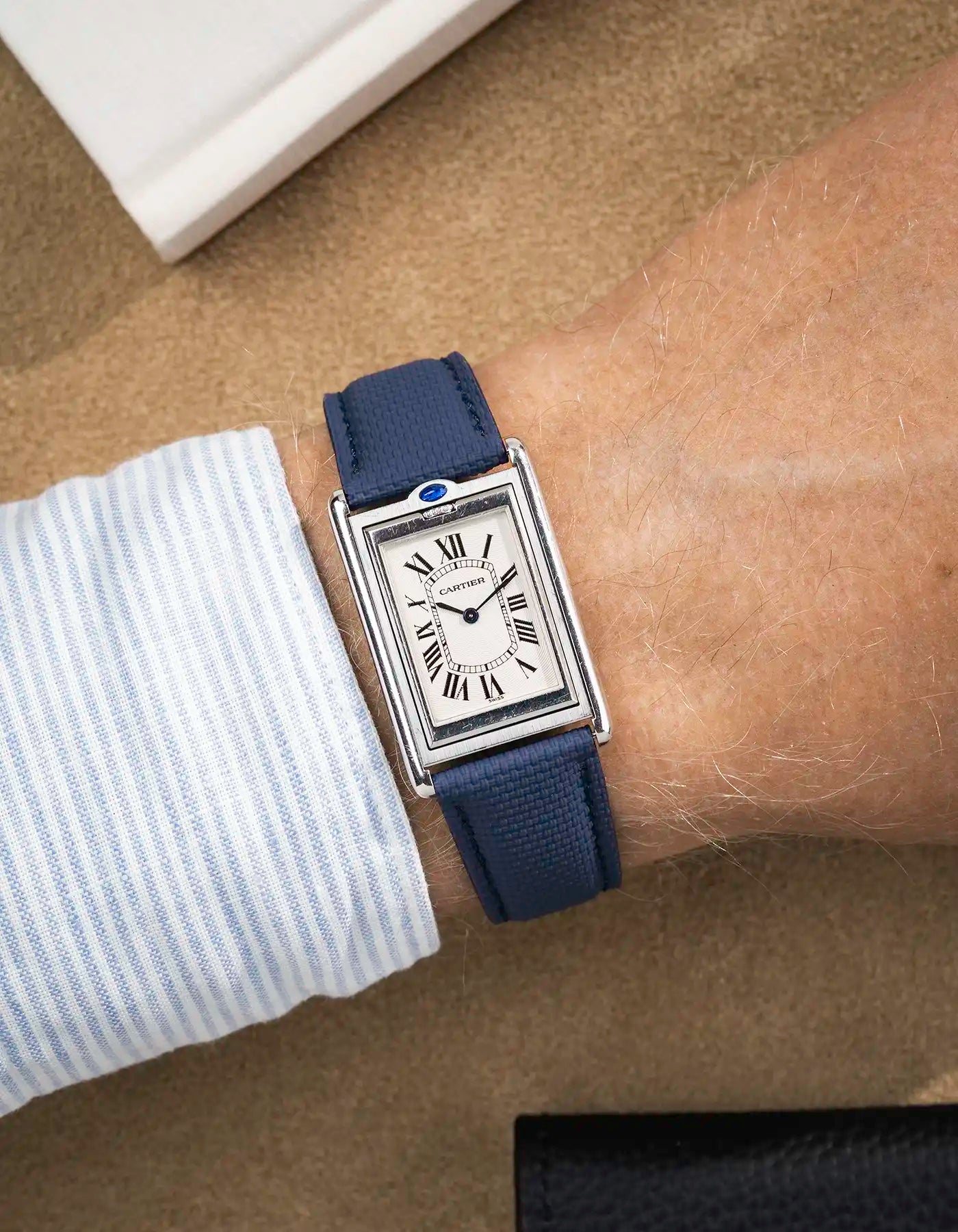 Blue rubberised sailcloth strap variant styled with rectangular silver watch on wrist