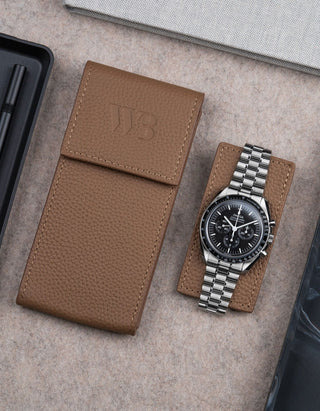 Brown leather watch pouch by Wristbuddys with Omega Speedmaster placed alongside closed case – stylish leather travel pouch for watches