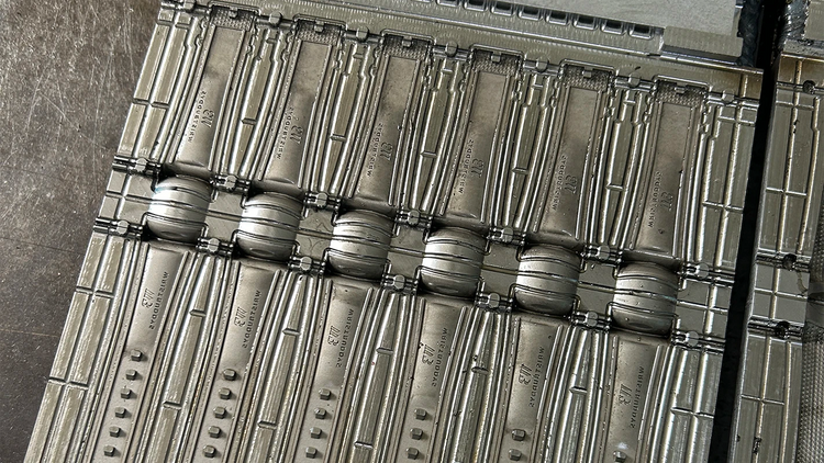 Close-up of stainless steel mold used in Wristbuddys rubber strap production, maintained for precision and durability