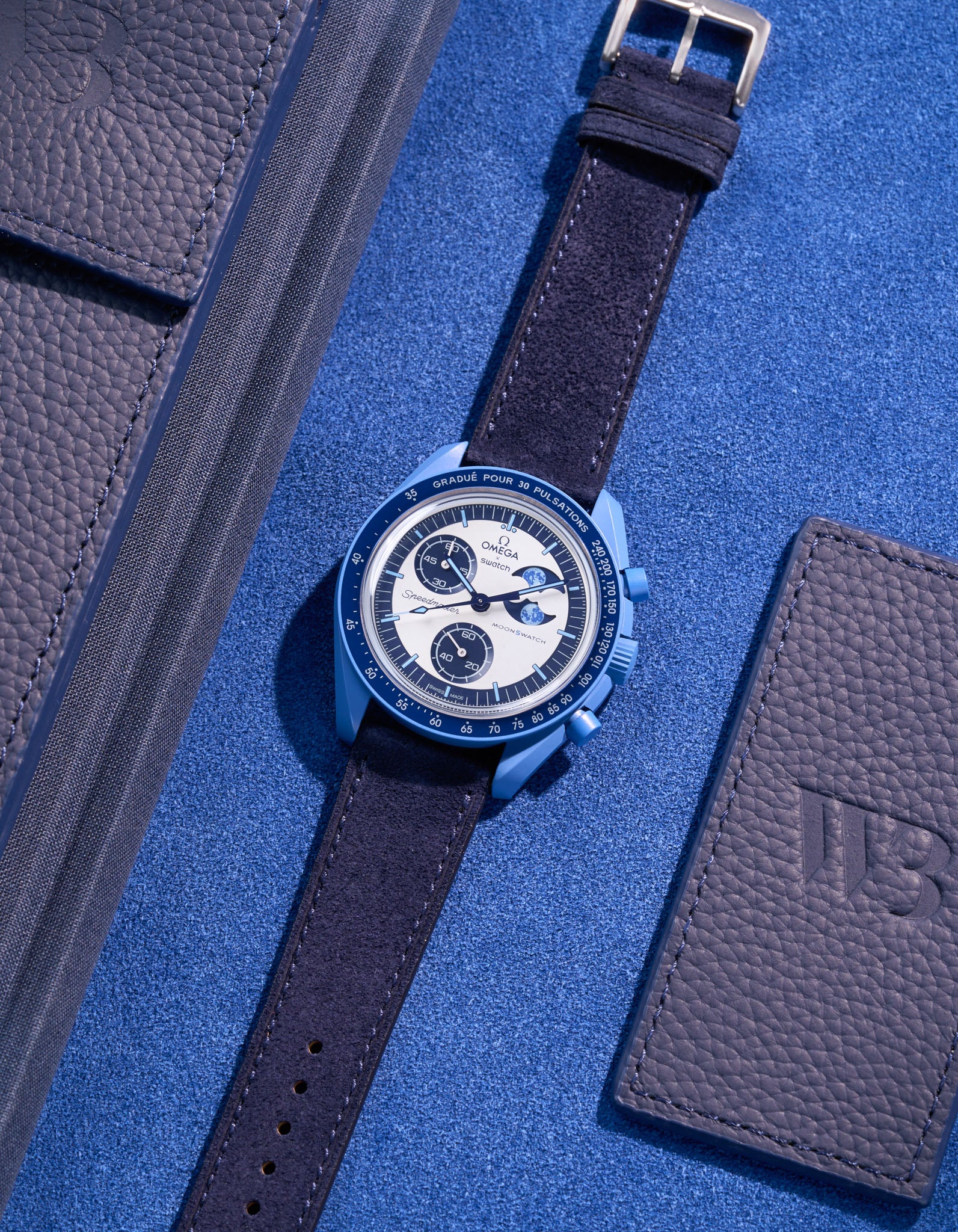 Flat lay of Omega X Swatch Mission to Super Blue Moonphase with Dark Blue suede leather strap