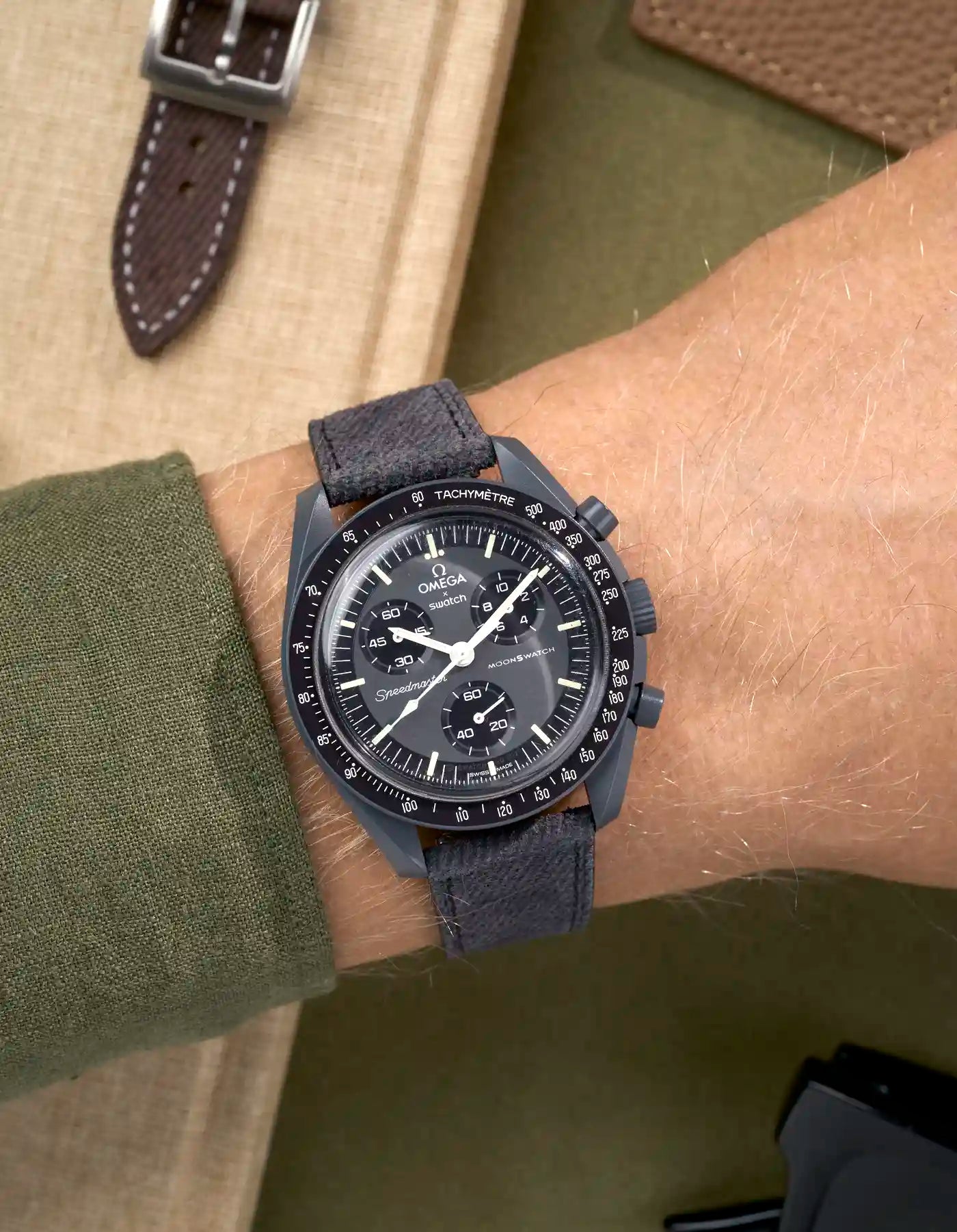 Dark grey denim watch strap on Omega x Swatch Mission to Mercury shown on wrist, styled with quick-release function