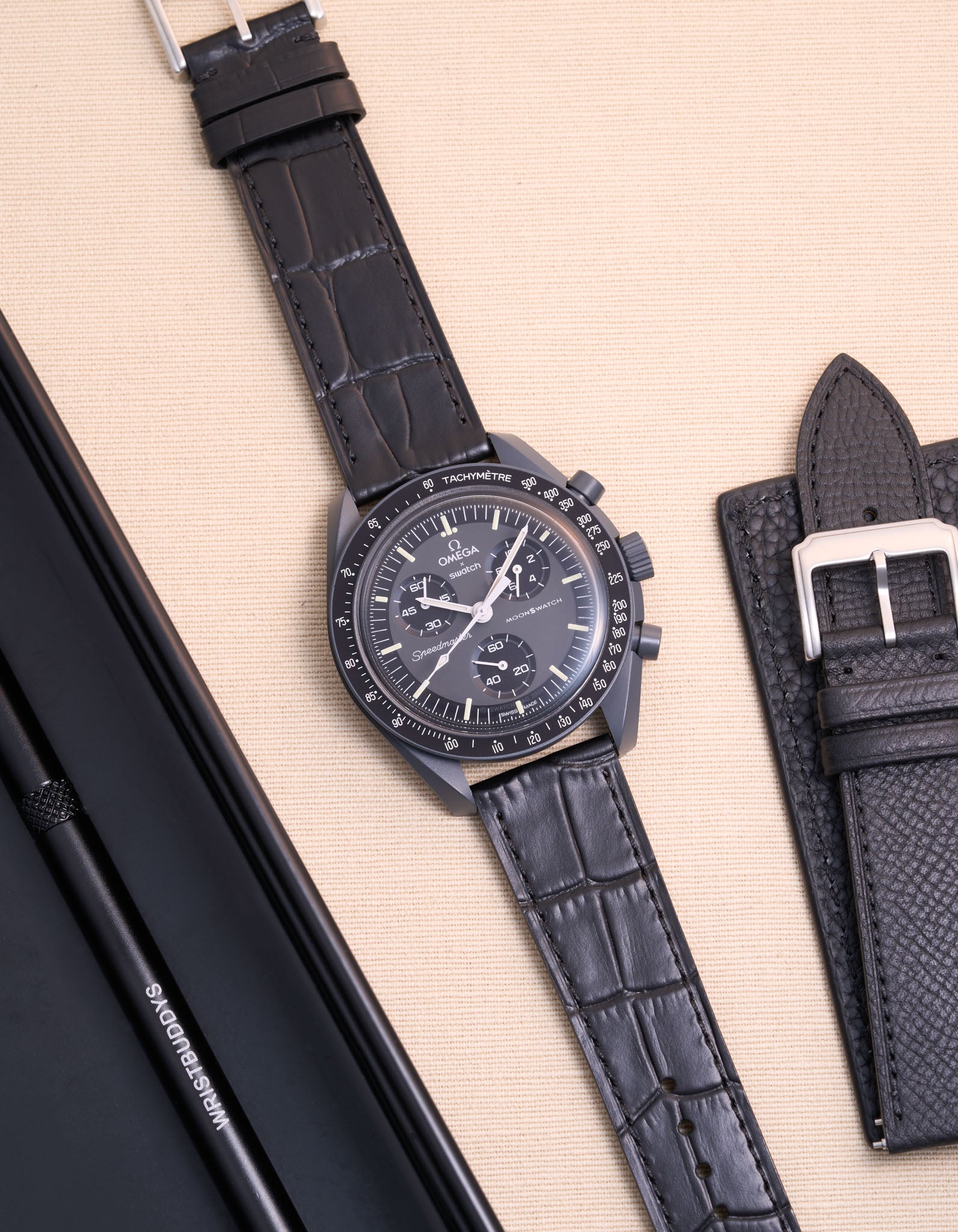 Flat lay of Omega X Swatch MoonSwatch mission to Mercury with black embossed alligator leather strap