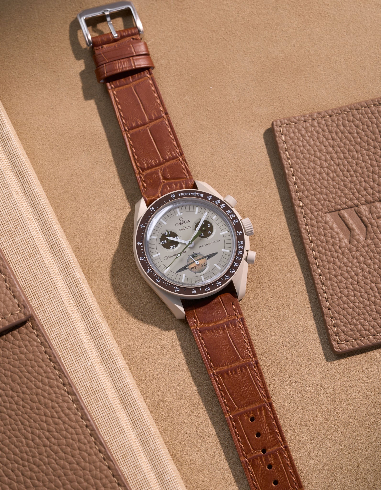 Flat lay of Omega X Swatch MoonSwatch Mission to Saturn with light brown embossed alligator leather strap