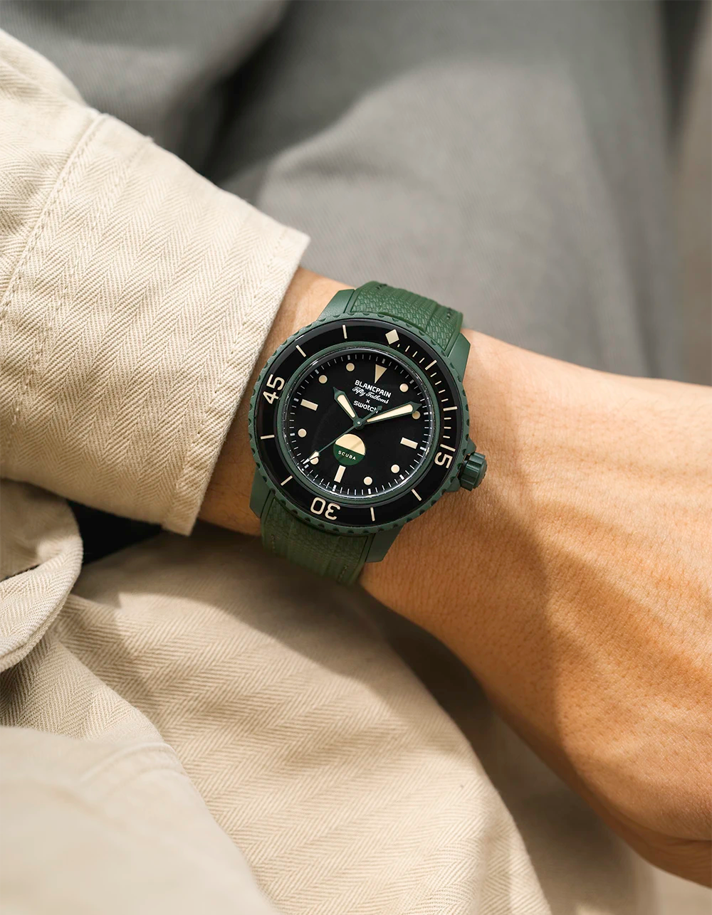 Green Vertech Rubber Watch Strap on a wrist with the Blancpain X Swatch Green Abyss Watch with beige jacket and grey background. 