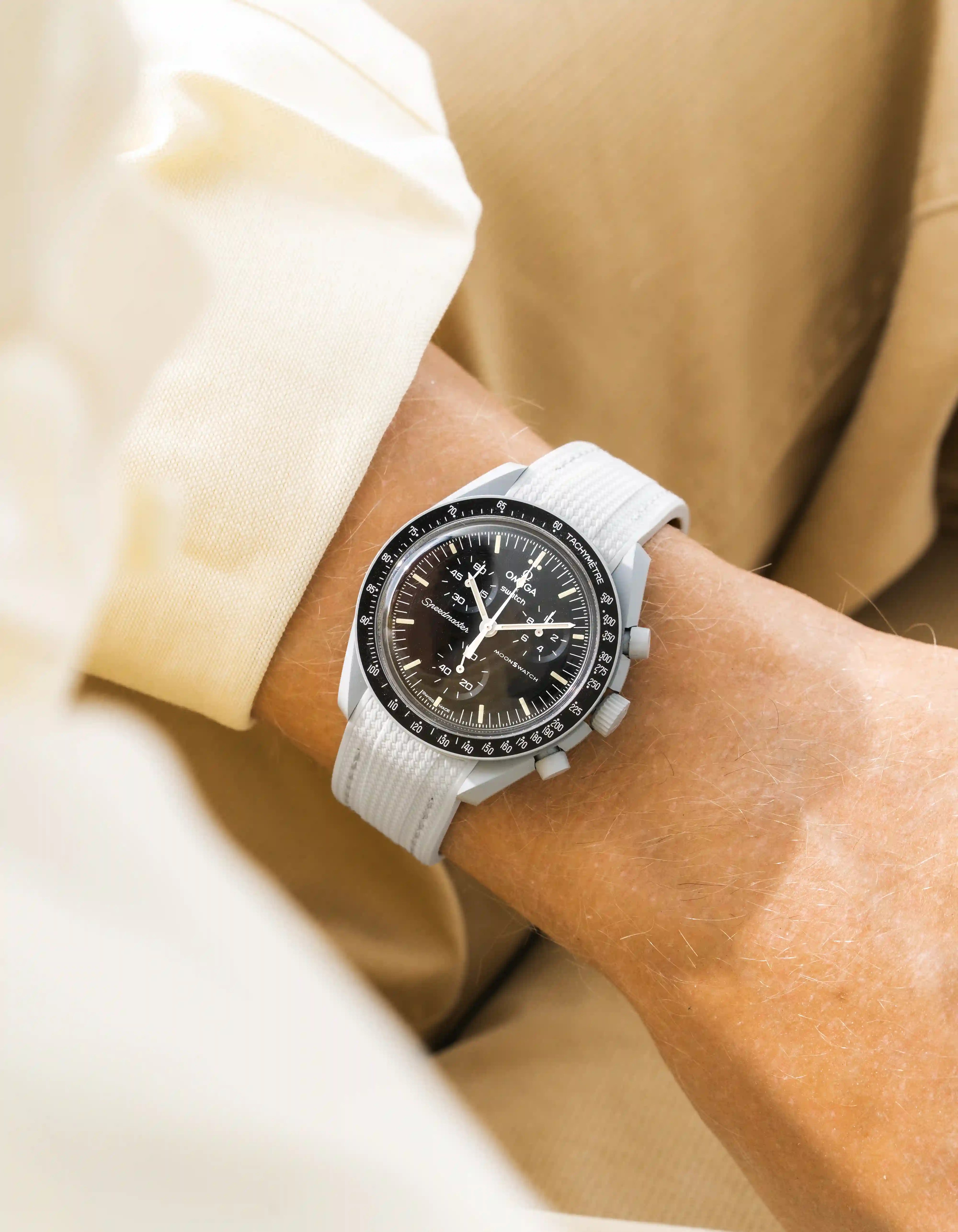 Grey rubber strap for Omega MoonSwatch Mission to the Moon – wrist shot with beige outfit