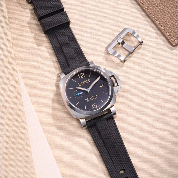 Panerai Luminor Marina watch with black FKM rubber strap and stainless steel buckle placed on beige fabric background