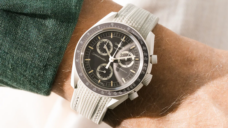 Omega x Swatch MoonSwatch Mission On Earth Desert with brown dial on sand beige rubber strap, worn on wrist — Wristbuddys MoonSwatch Desert collection
