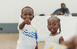 Two joyful children sharing a playful moment, symbolizing the happiness and brighter futures made possible through the Feed a Buddy program.