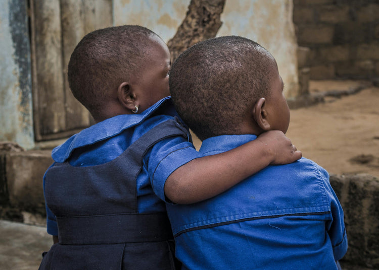Two children embracing each other in a moment of comfort and friendship, representing the spirit of unity and kindness behind Wristbuddys’ Feed a Buddy project.