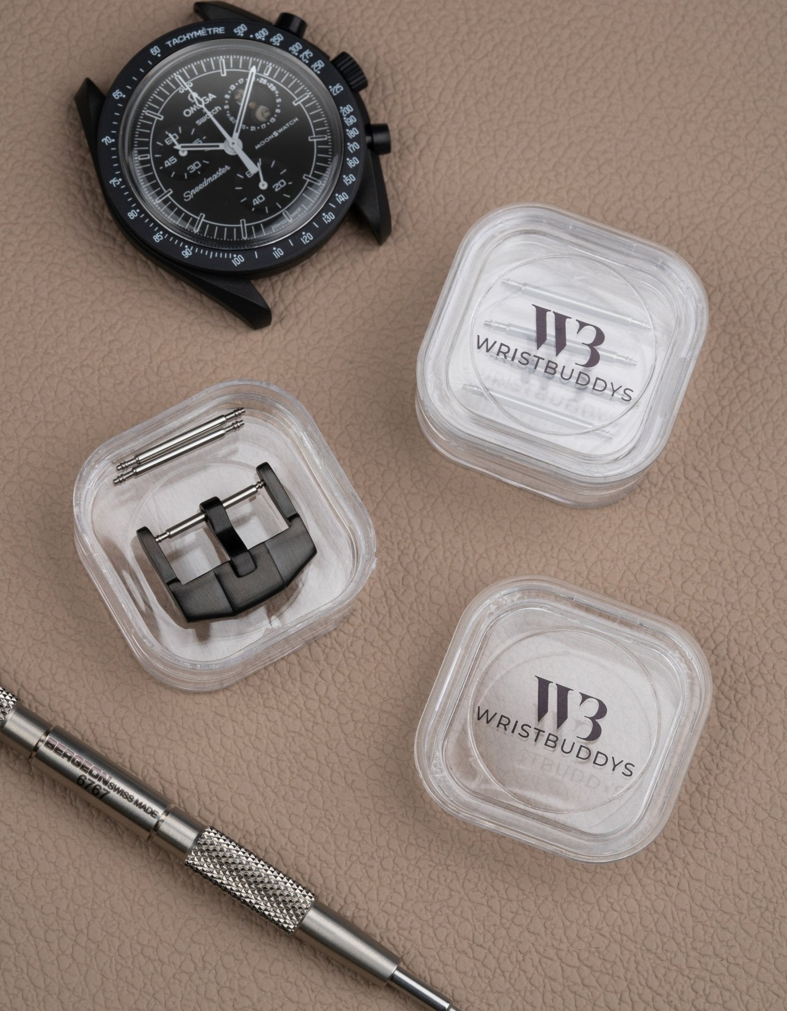 Premium buckle in black for watch straps, shown with spring bars and Wristbuddys tool