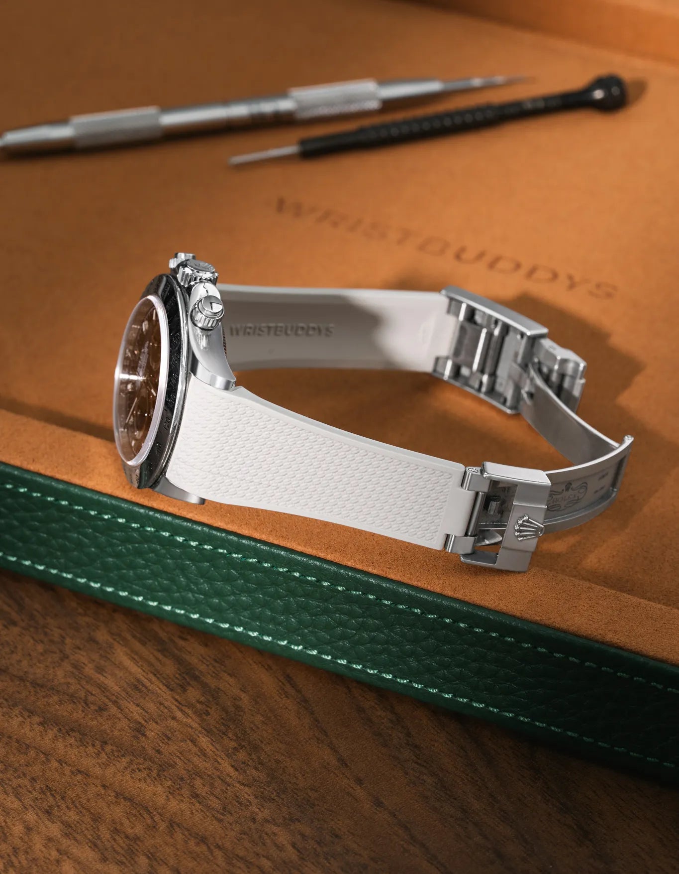 Beige Vertech FKM rubber strap for Rolex Daytona 116520, integrated fit with original clasp, resting on a leather watch tray with tools.