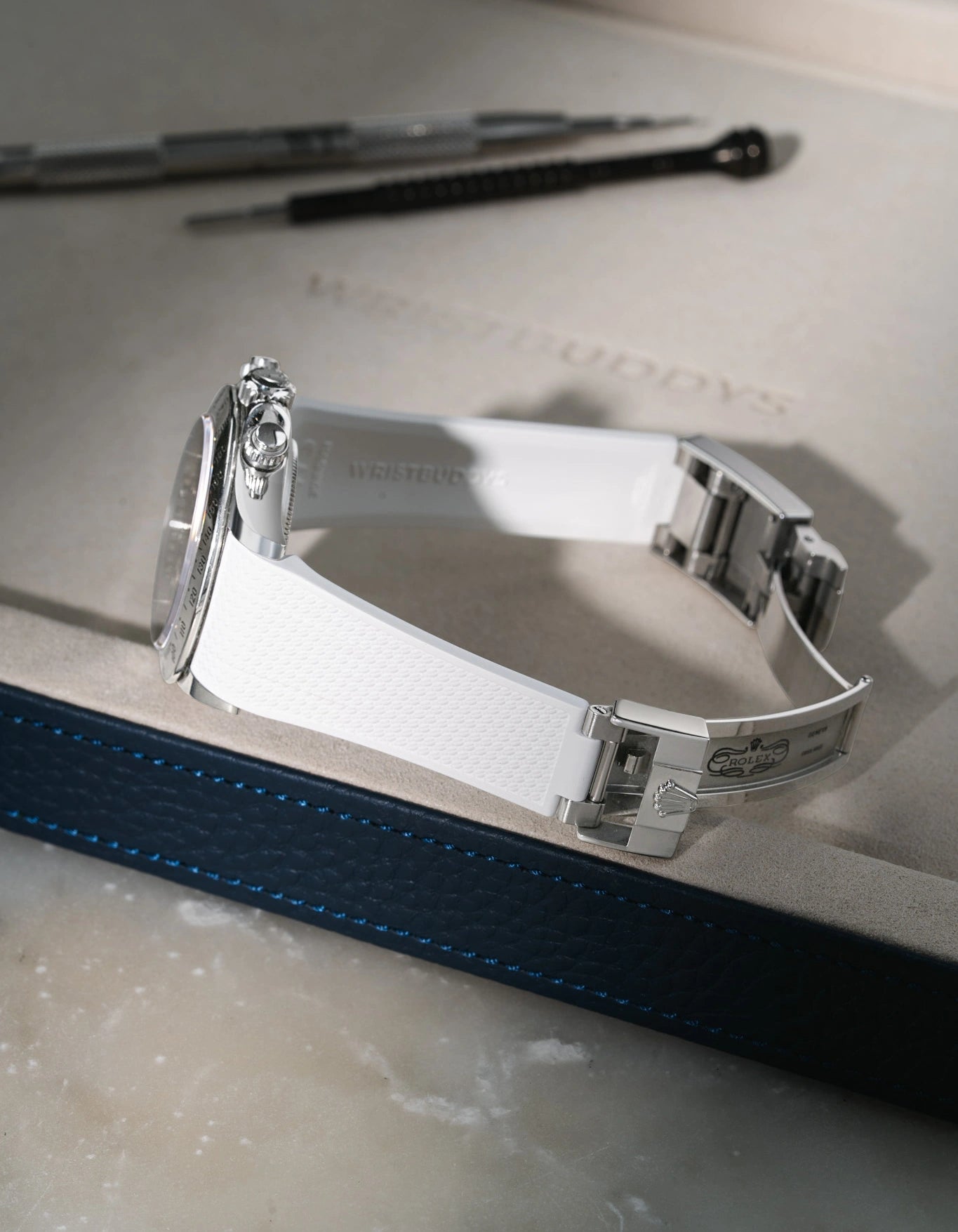 White Vertech FKM rubber strap for Rolex Daytona 116520, custom integrated fit with original steel clasp, resting on a white valet tray.