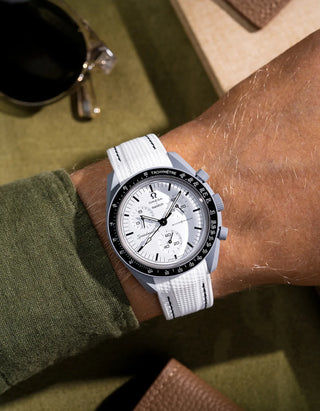 Custom white rubber strap with black stitching for MoonSwatch 1965, shown on wrist with crisp contrast