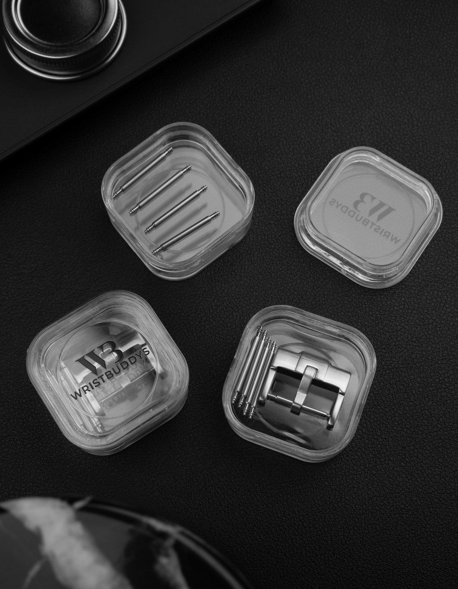 Silver standard watch strap buckle and spring bars in Wristbuddys packaging black background