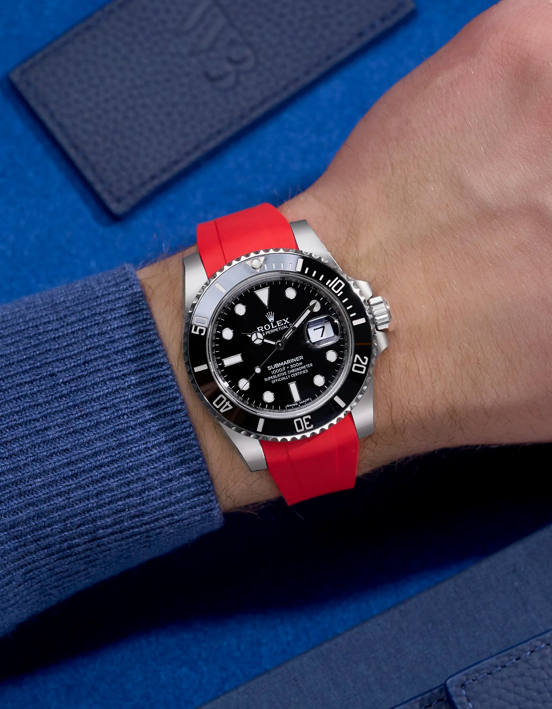 Rolex Submariner 116610LN or 114060LN with red integrated rubber strap on wrist, paired with original clasp