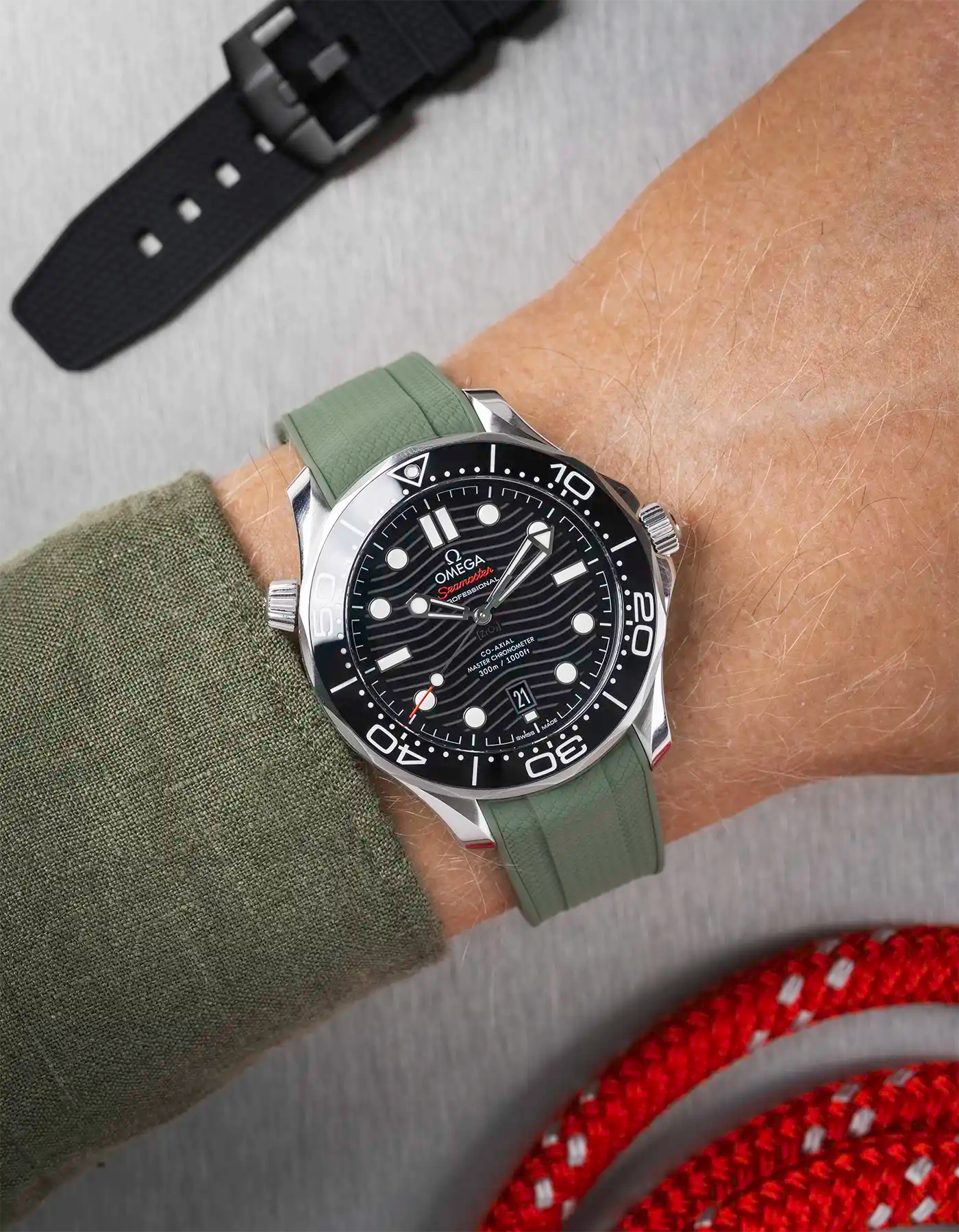 Omega Seamaster 300 Diver with black dial on wrist, paired with dark green Vertech FKM rubber strap