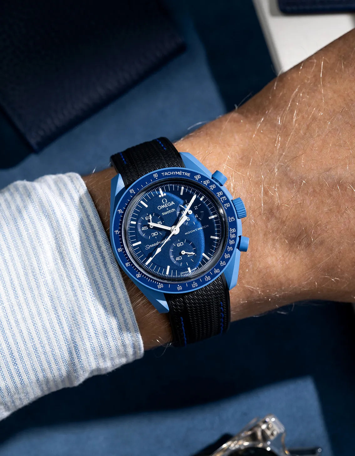 Black rubber strap with blue stitching for Omega MoonSwatch, shown on wrist with curved-end Vertech design