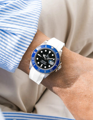 White Vertech FKM rubber strap integrated for original clasp on Rolex Submariner 126619LB "Cookie Monster" 18k white gold, blue ceramic bezel, black dial, straight front-facing wrist shot, Vertech crosshatch texture clearly visible on white strap, light blue striped linen shirt sleeve, cream background