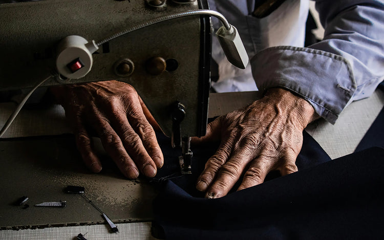 Hands sewing leather on a machine, showing the craftsmanship behind Wristbuddys watch straps.
