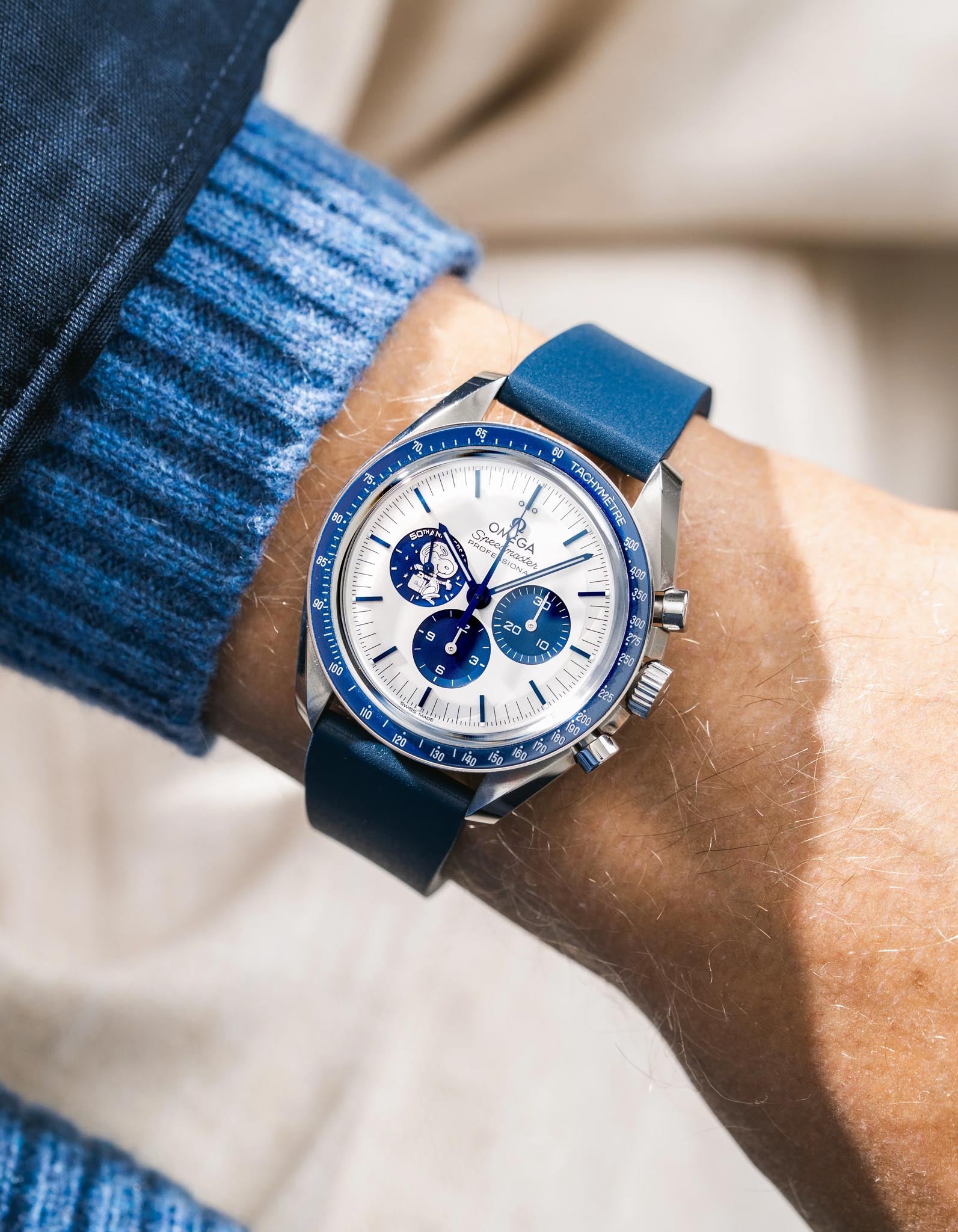 Blue Omega Speedmaster with a detailed face on a wrist, wearing a blue Navy blue CTS FKM Rubber Strap 19-22mm  woth a blue sleeve.